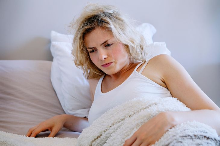 Person experiencing a groggy feeling in bed