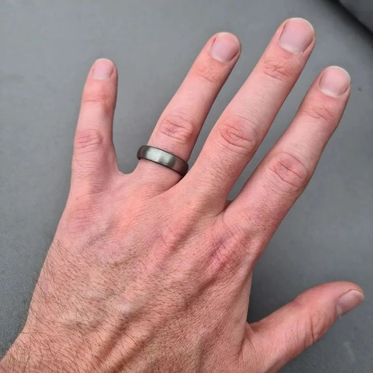 A user demonstrating the correct visual alignment of a smart ring on their index finger